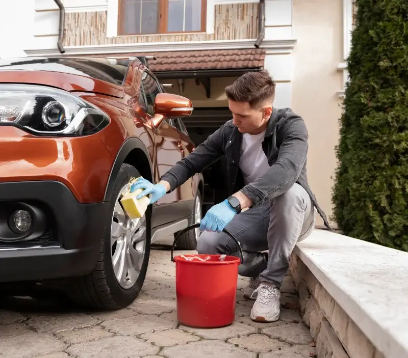 Lavage auto à domicile Saint-Romain-le-Noble : professionnel intervenant sur un véhicule